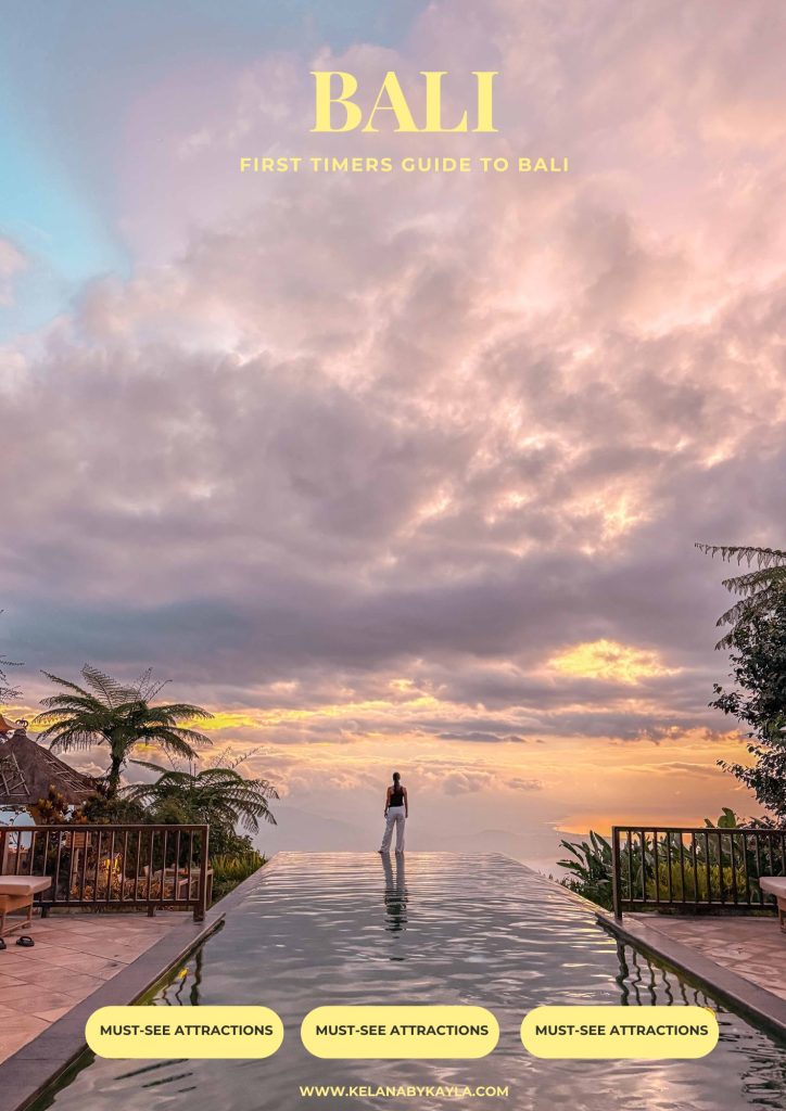 A person stands at the edge of an infinity pool at sunset, overlooking tropical scenery in Bali. The sky is dramatic with colorful clouds. Text reads: Bali Travel Guide – First Timers Guide to Bali.